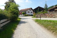 Ein Bild von einem Weg, der zu einem denkmalgeschützen Bauernhaus führt.