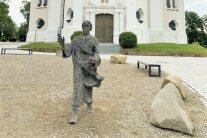 Platz vor einer Kirche mit Christus-Skulptur